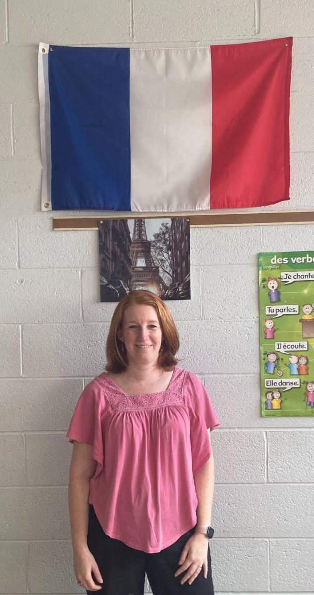 Madame Alicia Garnier poses with the flag for her country.