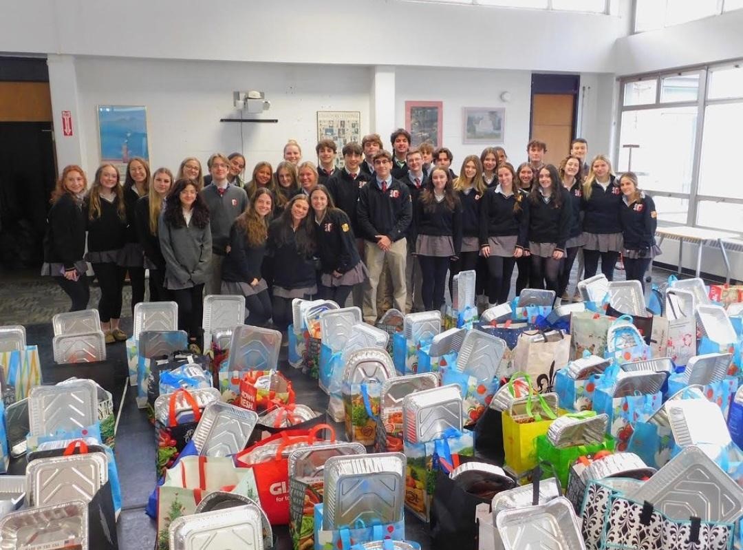 Archbishop Carrolls Community Service Corps members stand proudly behind the Thanksgiving Day meals they put together with the help of donations from students and Carroll families.