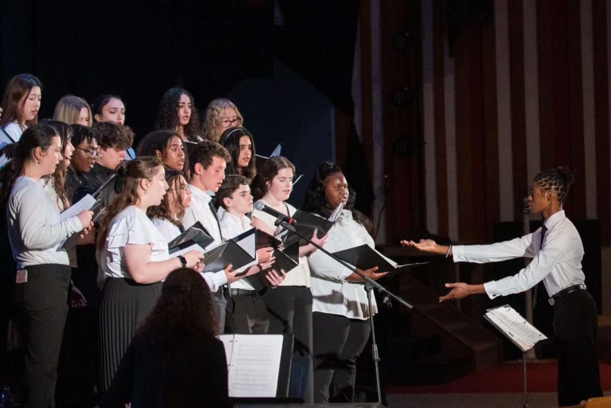 During the annual spring concert, junior Daniel Peterkin debuts his talent at conducting the choir.