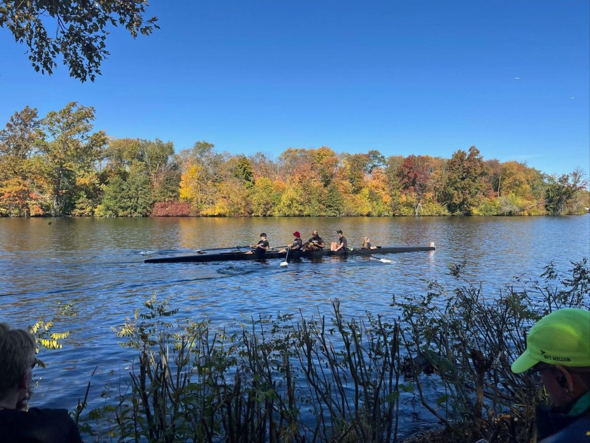 Senior Colin McClarren, junior Julian McPherson, junior Roland Montgomery, sophomore John Smith, and junior Mia Perez compete in the Head of the Charles regatta for Archbishop Carroll.
